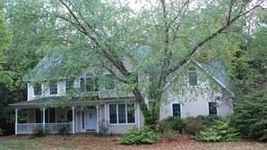 A two-story house with a front porch and a large tree in front. -  House in Lincoln, NH 2 Miles to Loon with Forest Ridge sports club access (Lincoln)