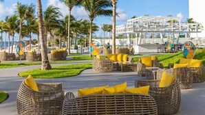 Ein Resort mit Außenbereich, Palmen und einem modernen Gebäude im Hintergrund.