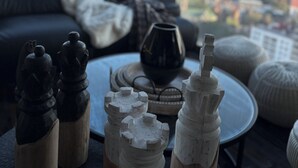 Un soggiorno moderno con un divano, un tavolino da caffè e elementi decorativi. Un'ampia finestra offre vista sulla città.