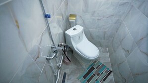 A bathroom with a toilet, shower, and a towel rack. - DORTOIR25CONSTANTINE (Constantine)