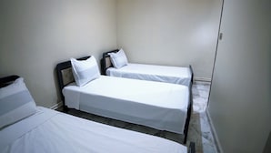 A small, clean room with two single beds and a nightstand. - DORTOIR25CONSTANTINE (Constantine)