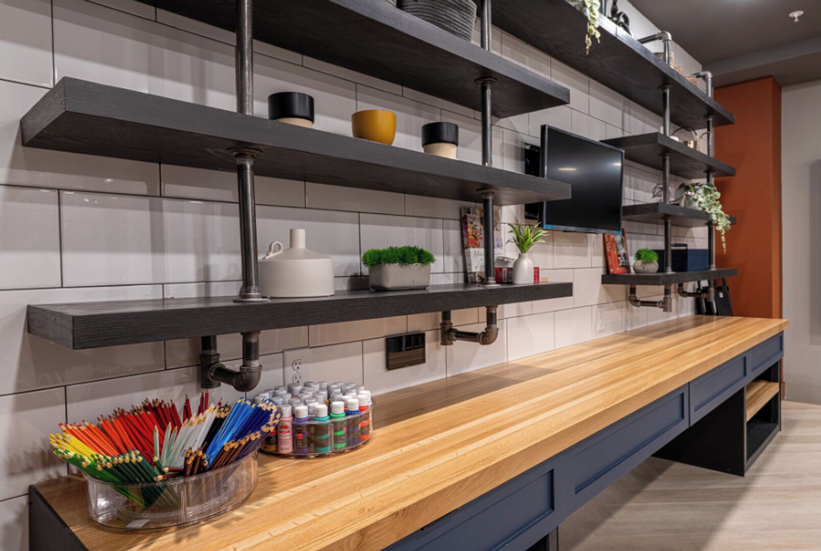 A modern kitchen with wooden countertops, built-in shelves, and a variety of kitchen items.