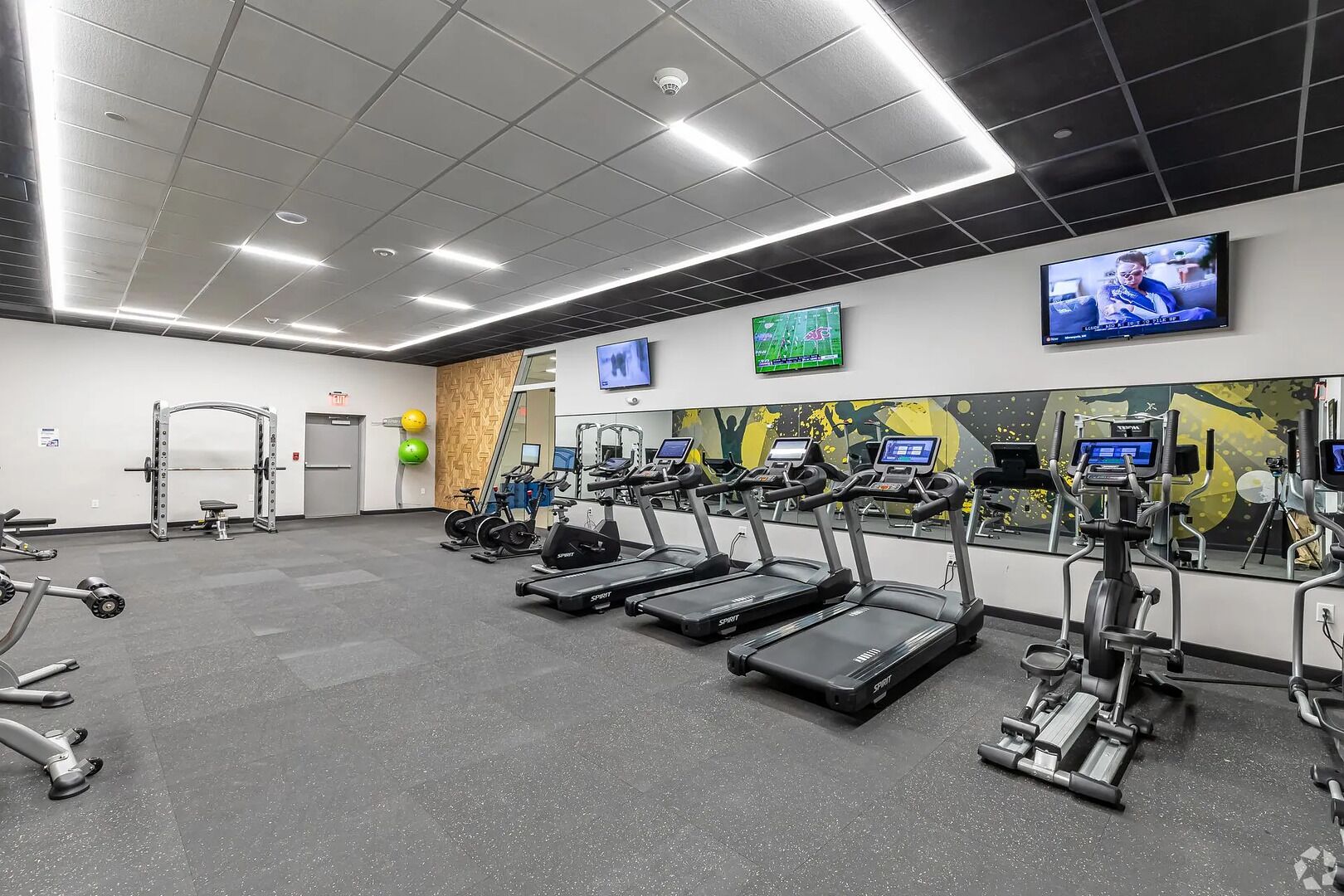 A gym with treadmills, stationary bikes, and weight machines.