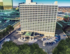A multi-story hotel with a central courtyard and a parking lot. - Landing | Beautiful 1BD, Game Room, Gym (Hartford)