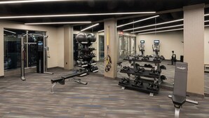 A gym with exercise equipment, weight racks, and a bench. - Landing | Incredible 2BD, Gym (Albany)