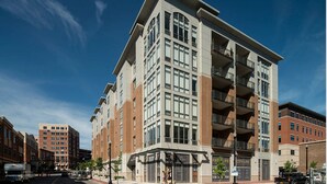 A multi-story building with a mix of commercial and residential units, featuring large windows and balconies. - Landing | Incredible 2BD, Gym (Albany)