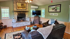 Una sala de estar acogedora con chimenea, asientos cómodos y televisor.