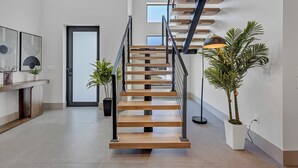 Um interior moderno com escada de madeira, plantas em vasos e design minimalista.
