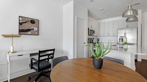 A modern kitchen with white cabinets, a stainless steel refrigerator, and a microwave. - Landing | Spectacular 1BD, Yoga Studio, Clubhouse (Raleigh)