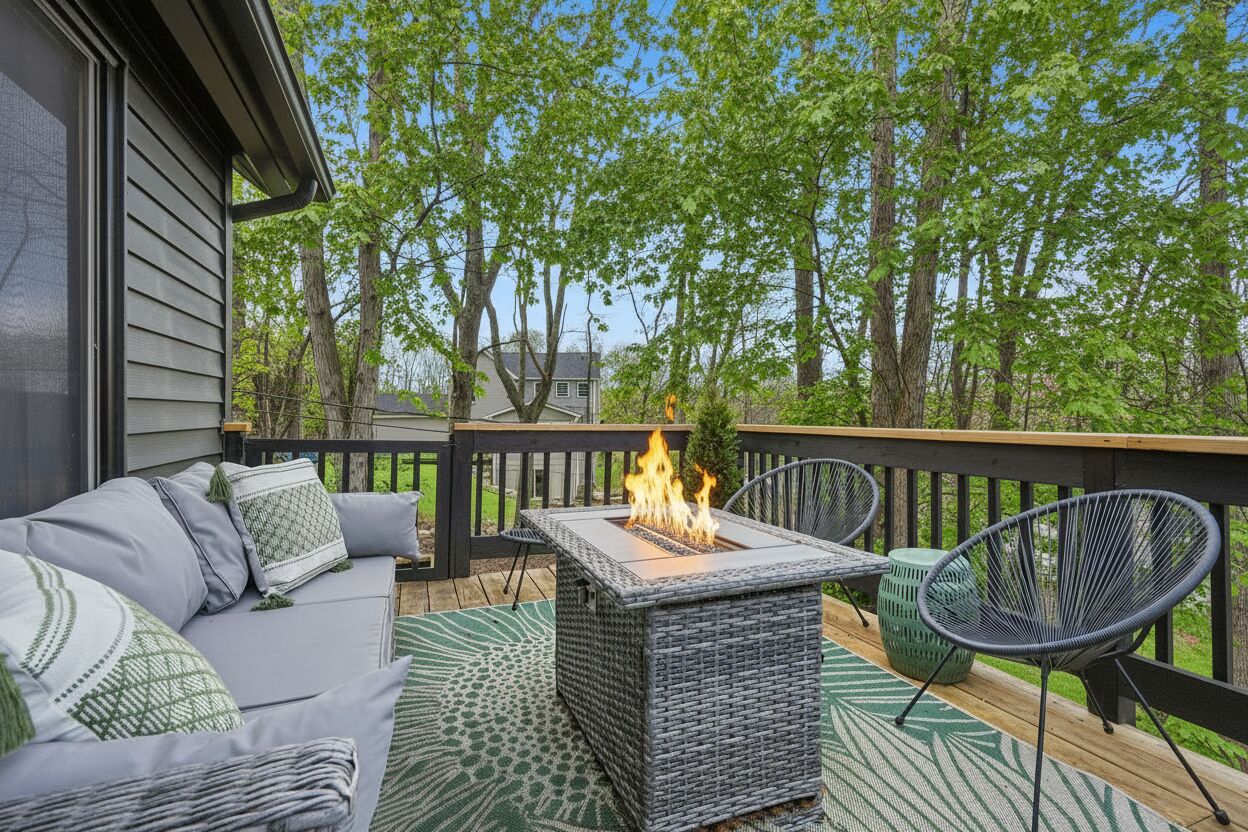 A deck with a fire feature, outdoor furniture, and a view of trees.