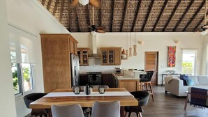 A spacious kitchen with wooden cabinets, a central island, and a dining area with chairs.