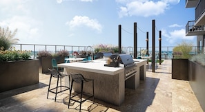 A rooftop patio with a bar area, outdoor seating, and a view of the cityscape. - Landing | Chic 1BD in Uptown Charlotte (Charlotte)