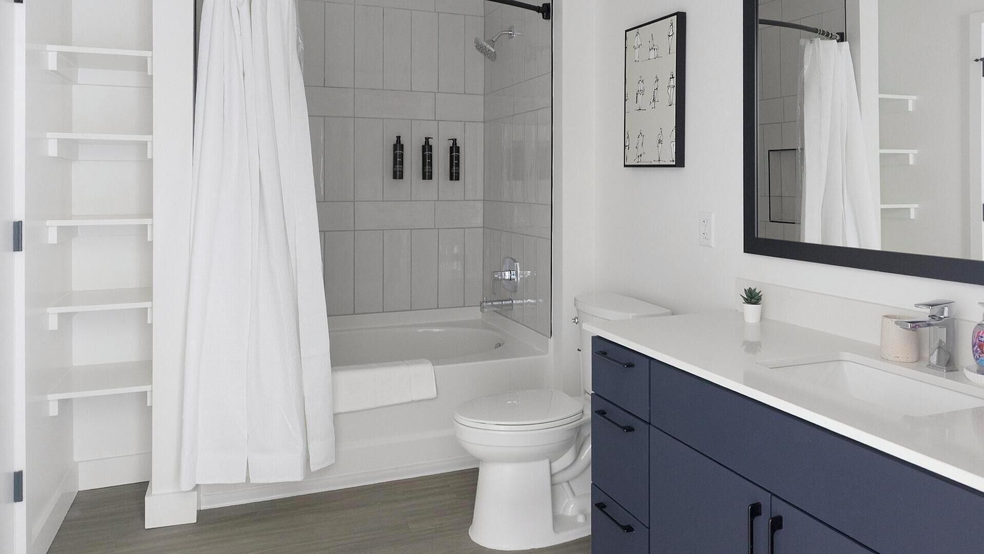 A modern bathroom with a bathtub, toilet, and vanity.