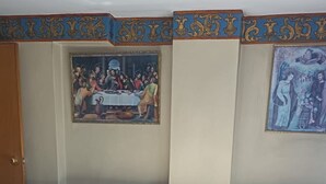 A bedroom with a bed, floral bedding, a wooden headboard, and two paintings on the wall. - Samana Wasi Urpicha (Cusco)