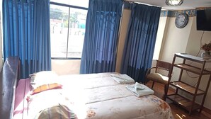A bedroom with a bed, a chair, a desk, and a window with curtains. - Samana Wasi Urpicha (Cusco)