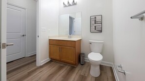 Une salle de bain avec un meuble-lavabo en bois, des toilettes et un miroir.