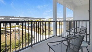 A balcony with a view of a swimming pool and a residential area. - Landing | Stunning 2BD, Gym, Clubhouse (Lakeland)