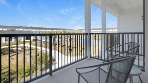 A balcony with a view of a swimming pool and a residential area. - Landing | Spectacular 2BD, Clubhouse, Gym (Lakeland)