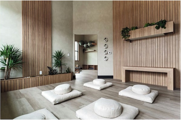 A modern spa room with wooden paneling, a reception desk, and a seating area with white cushions. - Landing | Spectacular 2BD, Clubhouse, Gym (Lakeland)