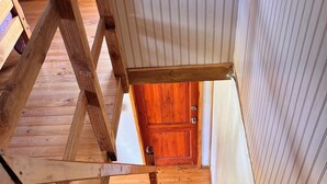 A wooden staircase leading to a door with a white panel wall. - Giardino Cabins in Lago Ranco (Lago ranco)