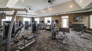 A gym with various exercise equipment, a ceiling fan, and a carpeted floor. - Landing | Modern 2BD, Clubhouse, Gym (Greer)