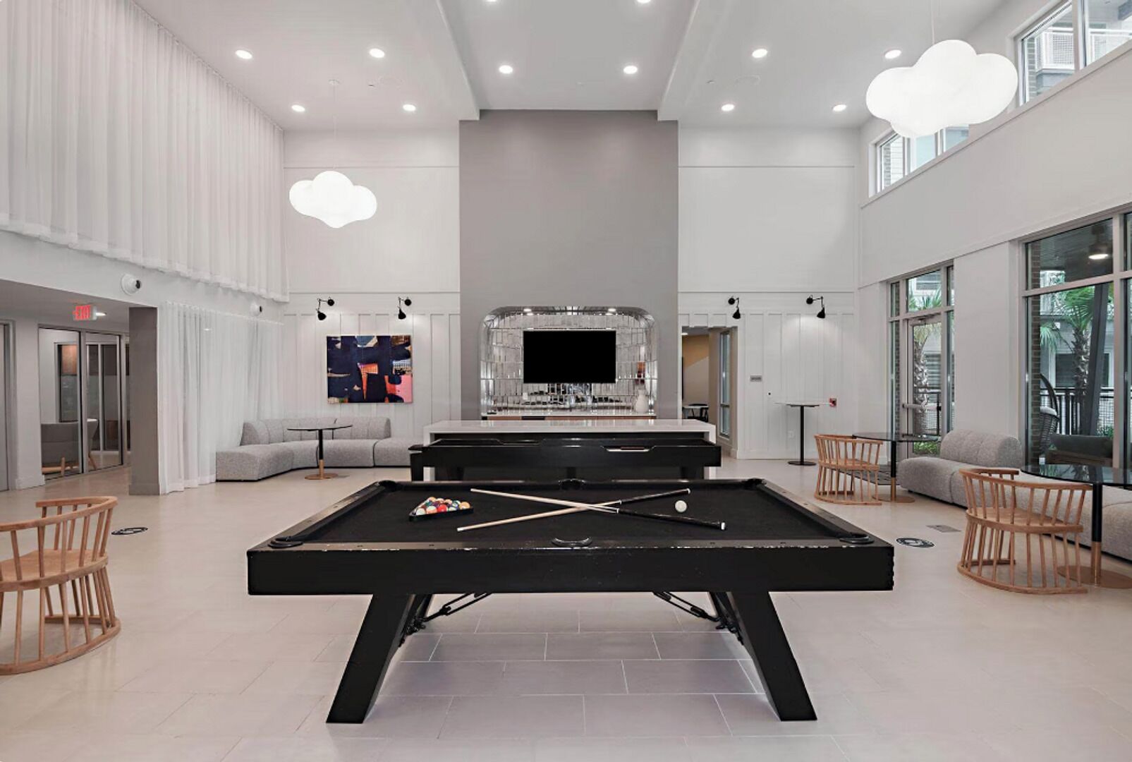 A modern indoor pool area with a pool table, lounge seating, and a bar.