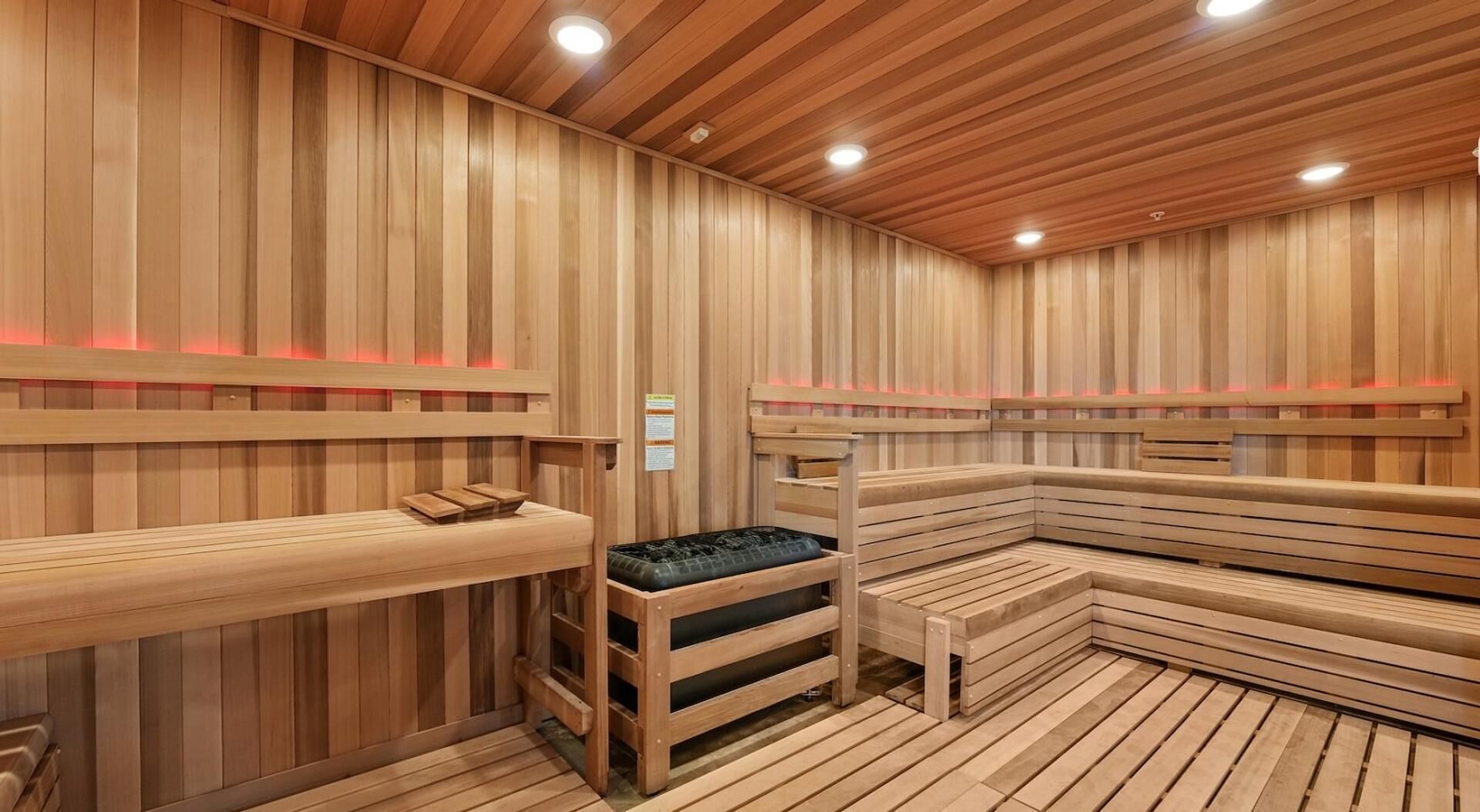 A sauna with wooden benches and benches with cushions.