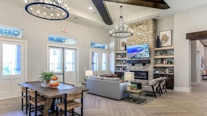 Tilava olohuone, jossa on kivinen takka, suuri taulutelevisio ja mukavat istuimet.