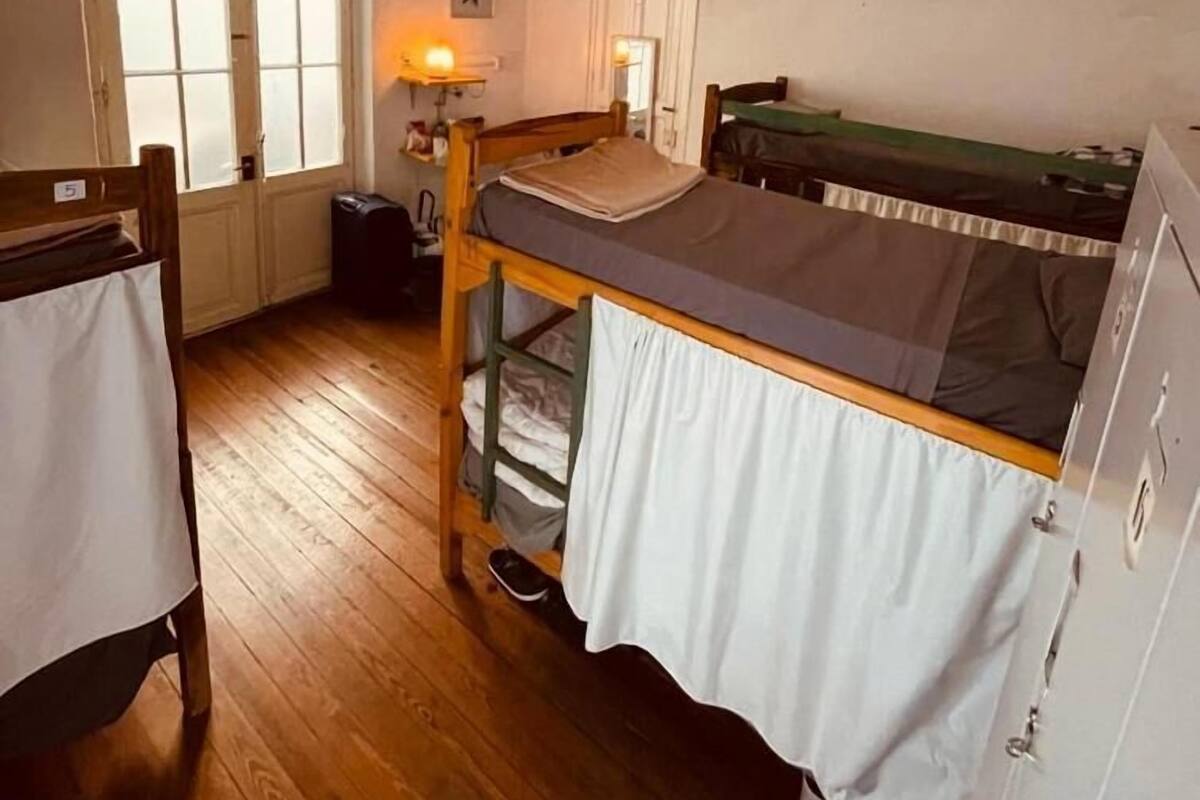 A small, compact room with a bunk bed, a desk, and a chair.
