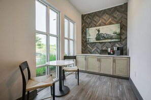 A modern kitchen with large windows, a dining area with a round table and chairs, and a herringbone-patterned backsplash. - Landing | Incredible 2BD, Gym, Pool (Charlotte)