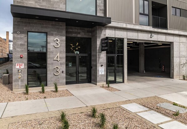 A modern building with a stone facade, numbered 343, featuring a glass entrance and a parking garage. - Landing | Stunning Studio in Central City (Salt Lake City)