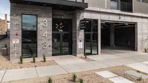 A modern building with a stone facade, numbered 343, featuring a glass entrance and a parking garage. - Landing | Modern 1BD in Central City (Salt Lake City)