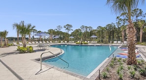 A swimming pool with lounge chairs and umbrellas, surrounded by palm trees and a fence. - Landing | Spectacular 2BD, Gym, Pool (Palm Bay)