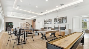 A spacious room with a pool table, a foosball table, and a dining area with chairs and a table. - Landing | Chic 2BD, Pool, Gym (Palm Bay)