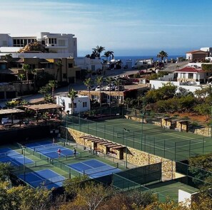 A tennis court surrounded by residential buildings, with a clear view of the sea in the background. - NEW! Luxury Condo Pedregal Ocean and City Views, 15min Walk to downtown (Cabo San Lucas)