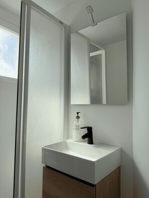 A bathroom with a white sink, a black faucet, a mirror above the sink, and a bottle of Pure Soap. - Fabulous 2-bedroom apartment with AC in charming Granada (Granada)