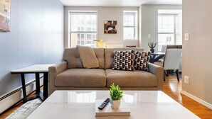 Un salon moderne avec un canapé, une table basse et une petite plante.