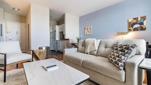 Ein modernes Wohnzimmer mit einer Couch, einem Couchtisch und einer Küche im Hintergrund.