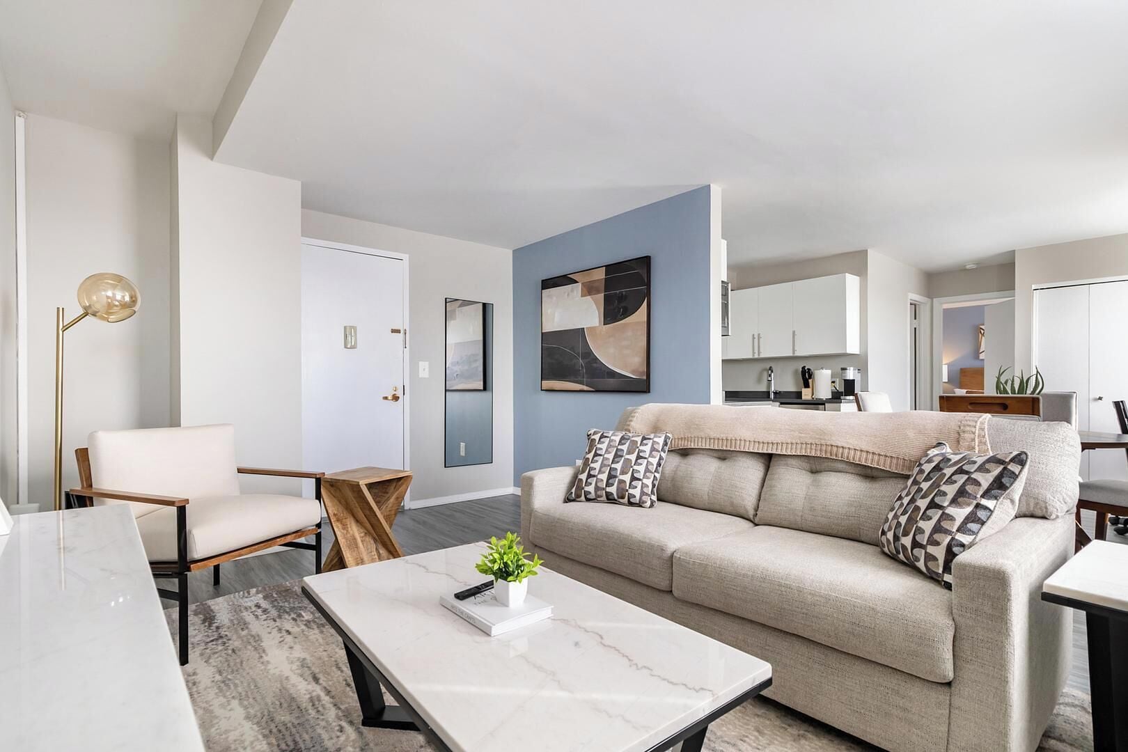 A modern living room with a sofa, a coffee table, a chair, and a floor lamp.