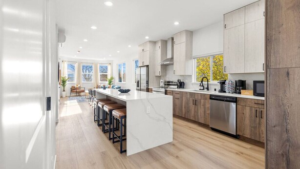A modern kitchen with a central island, wooden cabinets, and stainless steel appliances. - Modern Comfort in Seattle, 10 mins to downtown (Seattle)