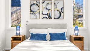 A bedroom with a bed, two bedside tables, a window, and three abstract paintings on the wall. - Modern Comfort in Seattle, 10 mins to downtown (Seattle)