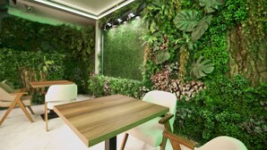 A room with a green wall, a wooden table, and white chairs.