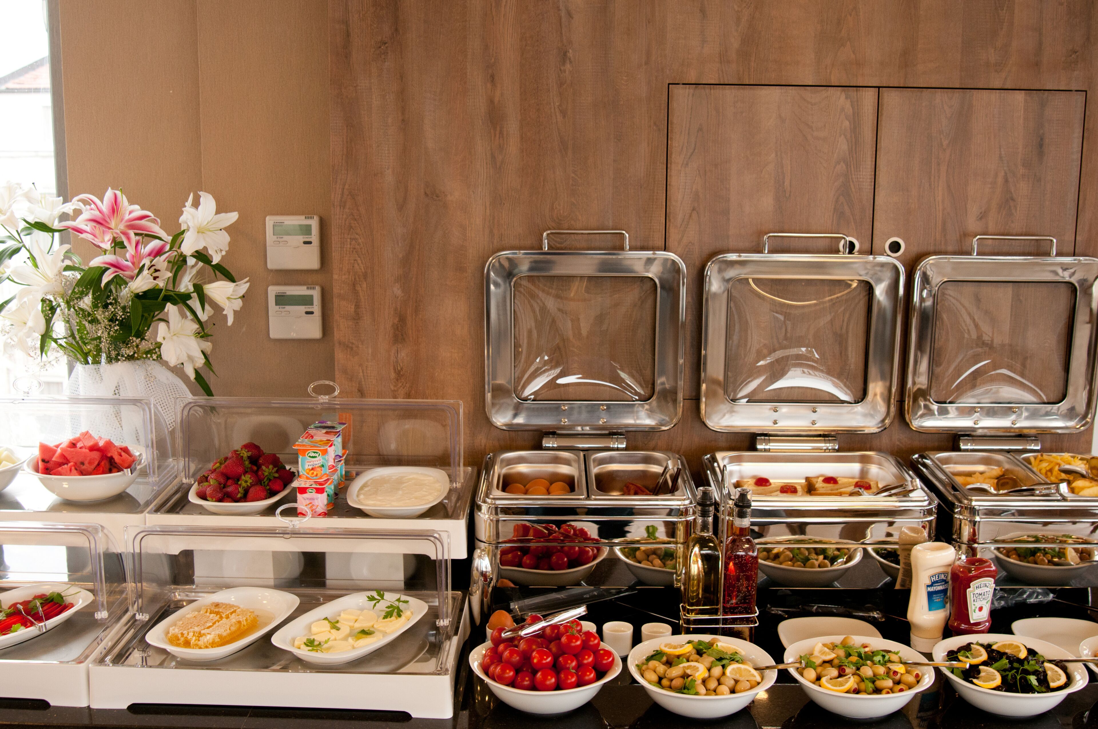 Een buffet met diverse gerechten en een bloevas.