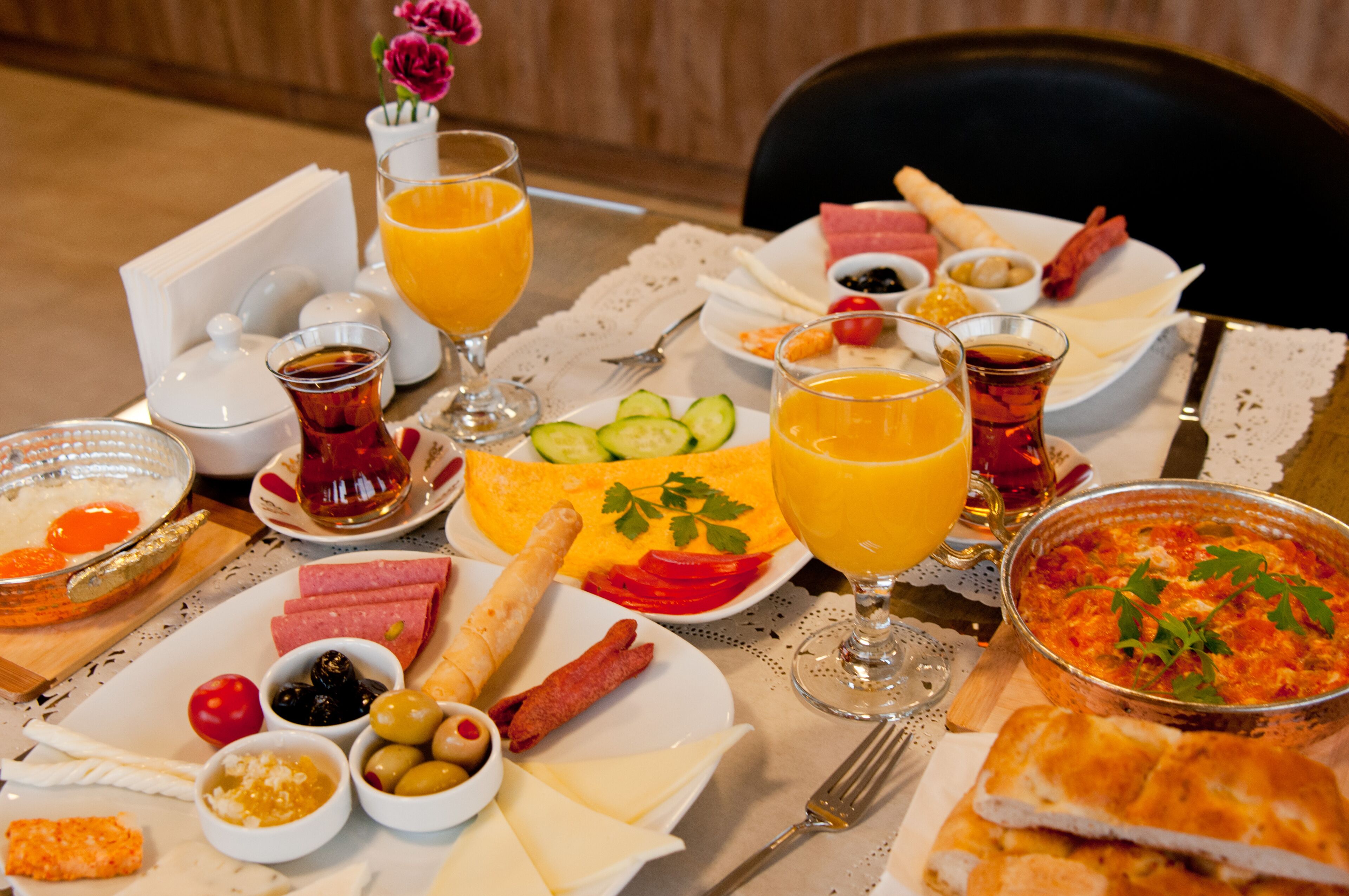 A breakfast table with various dishes, including eggs, cheese, bread, and fruit.