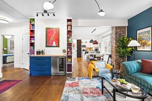 Ein modernes Wohnzimmer mit blauer Küche, einem Essbereich und einer Kücheninsel.