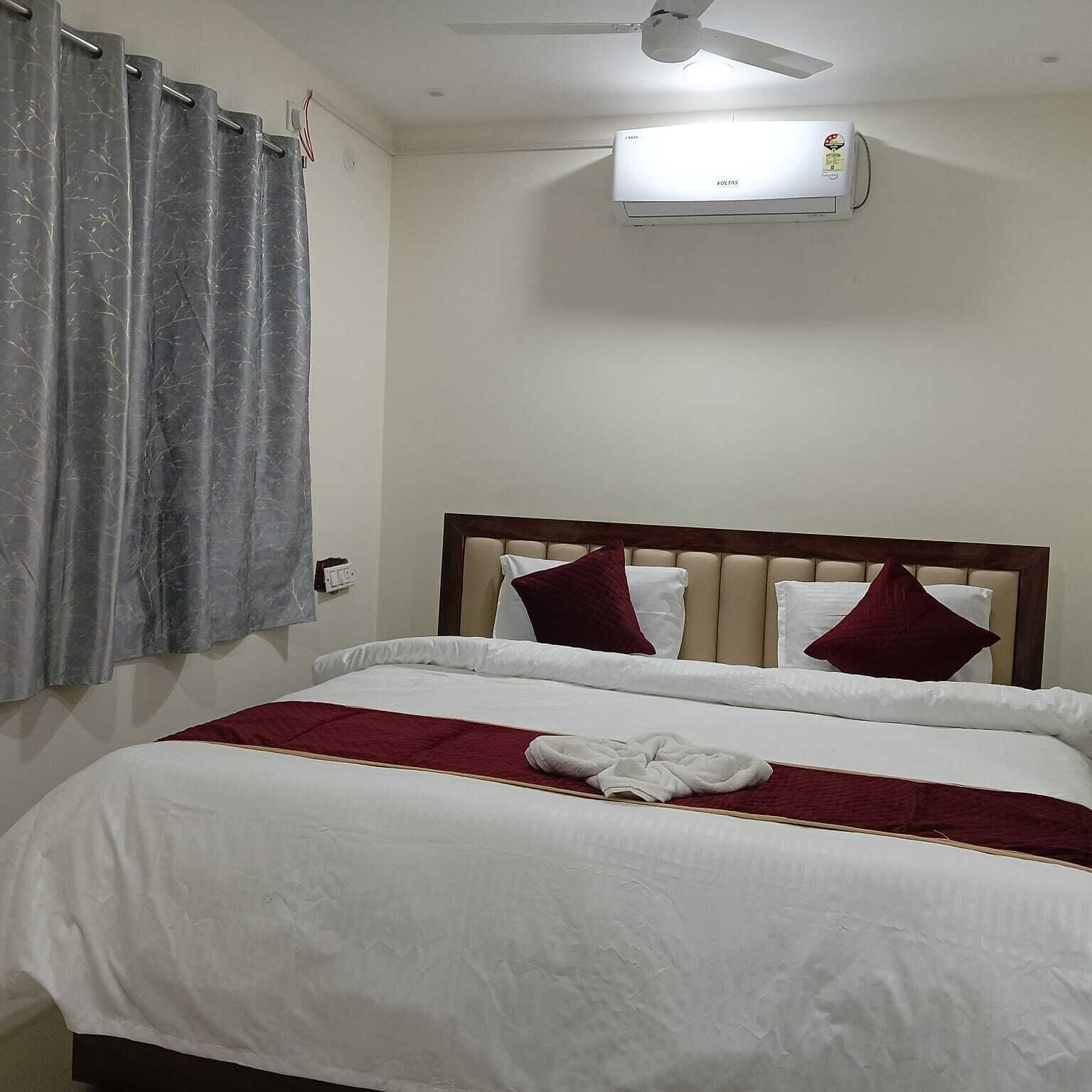 Une chambre d’hôtel équipée d’un lit, d’un ventilateur de plafond et d’un appareil de climatisation.