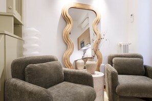 A modern living room with two grey sofas, a wooden-framed mirror, and a small table with a vase. - Easylife - Milano - Sarpi 6 - Chinatown (Milano)
