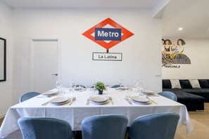 A dining area with a table set for six, a potted plant, and a wall sign reading "Metro La Latina". - Palacio Real DownTown. 5BR 3BTH. NEW (Madrid)