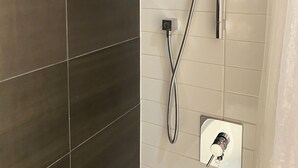A shower with a handheld showerhead and a wall-mounted control. - Modern Artistic Loft 5 minutes to Distillery District. Pet-Friendly! (Toronto)