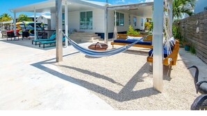 Zona exterior coberta amb piscina, gandules i un edifici al fons.